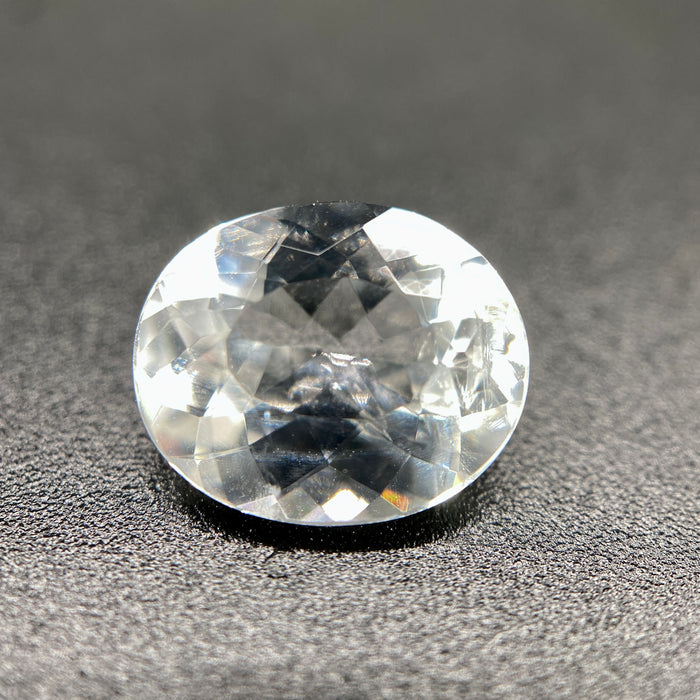 rare brazilian phenakite gemstone faceted oval shape on black background. available at sanctuaryofstones.com