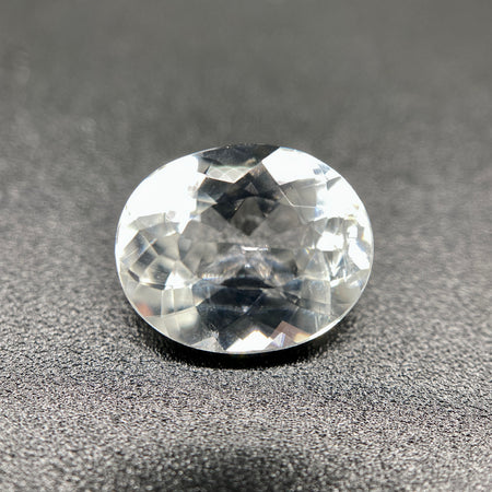 rare brazilian phenakite gemstone faceted oval shape on black background. available at sanctuaryofstones.com