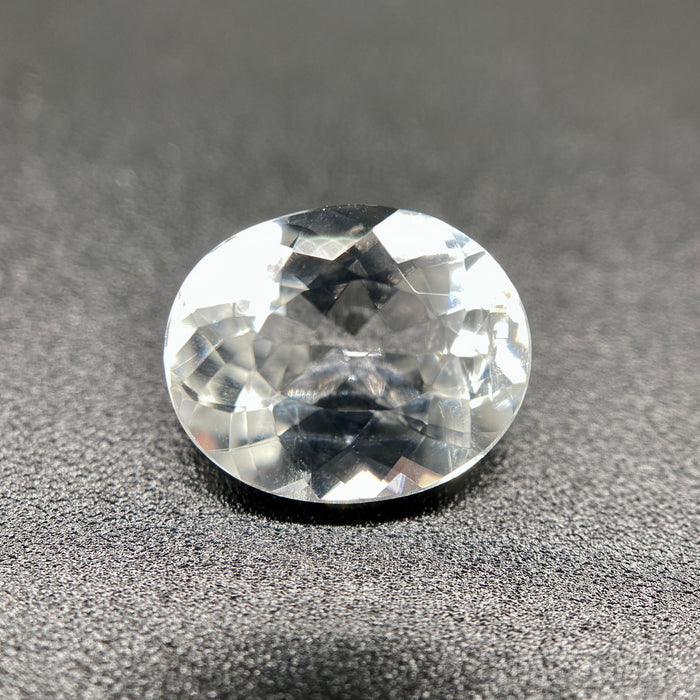 rare brazilian phenakite gemstone faceted oval shape on black background. available at sanctuaryofstones.com