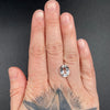 rare brazilian phenakite gemstone faceted oval shape on back of a hand to show size. available at sanctuaryofstones.com