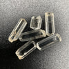 Top view of 6 pieces of Burmese phenakite hexagonal barrel stones on black background. available at sanctuaryofstones.com