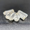 Top view of 6 pieces of Burmese phenakite hexagonal barrel stones on black background. available at sanctuaryofstones.com