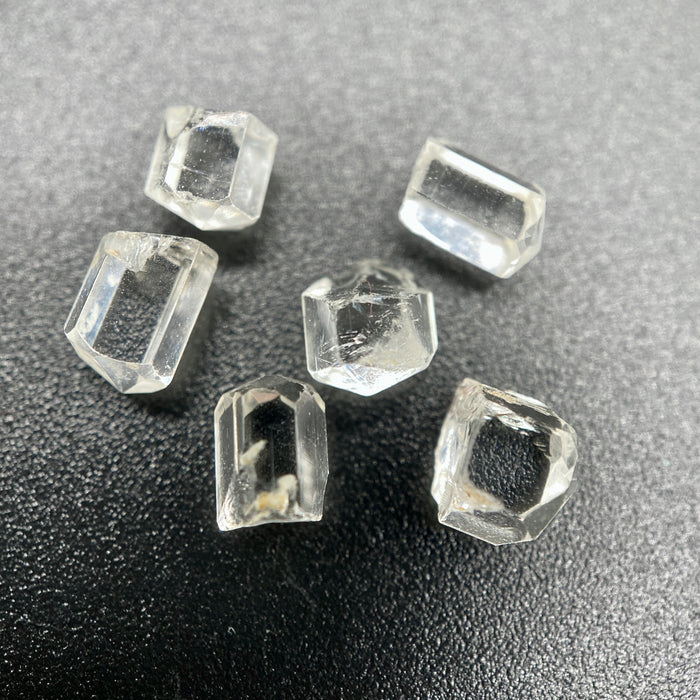 6-piece lot short Burmese phenakite crystals on black background. available at sanctuaryofstones.com
