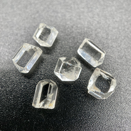 6-piece lot short Burmese phenakite crystals on black background. available at sanctuaryofstones.com