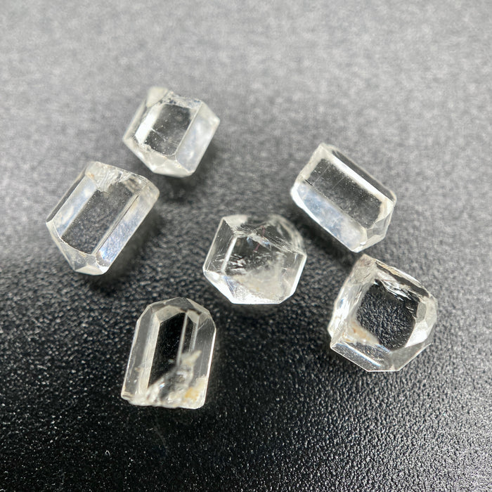 6-piece lot short Burmese phenakite crystals on black background. available at sanctuaryofstones.com