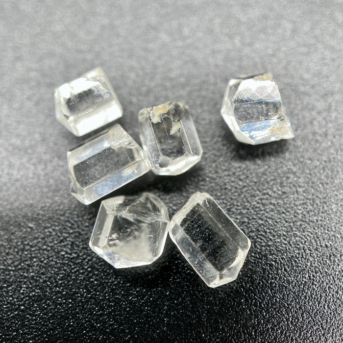 6-piece lot short Burmese phenakite crystals on black background. available at sanctuaryofstones.com