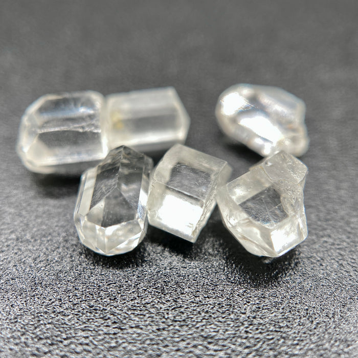 6-piece lot of short, fat, stubby Burmese phenakite crystals on black background. available at sanctuaryofstones.com