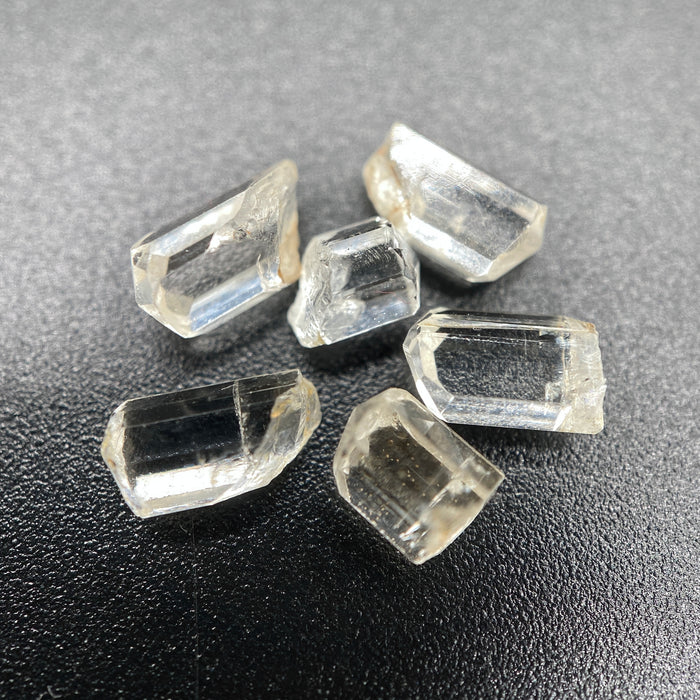 6-piece Burmese phenakite crystal lot on black background | available for sale at sanctuary of stones dot com sanctuaryofstones.com