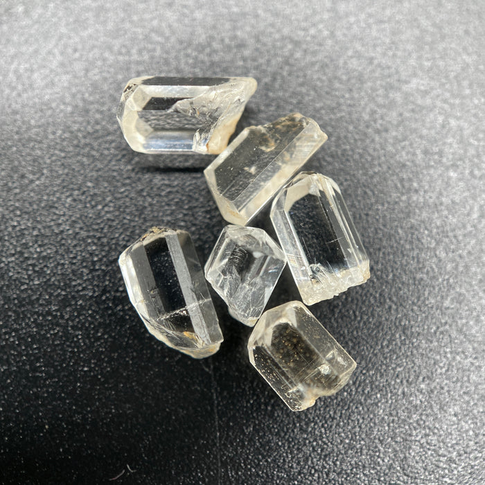 6-piece Burmese phenakite crystal lot on black background | available for sale at sanctuary of stones dot com sanctuaryofstones.com