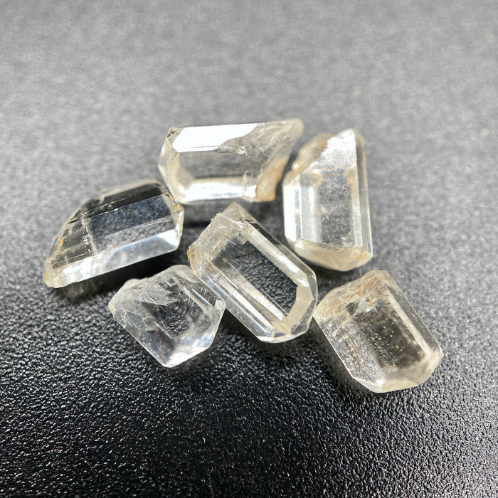 6-piece Burmese phenakite crystal lot on black background | available for sale at sanctuary of stones dot com sanctuaryofstones.com