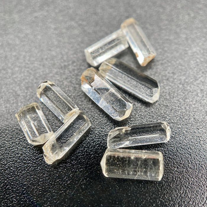 9-piece Burmese phenakite crystal lot on black background. Available at sanctuaryofstones.com