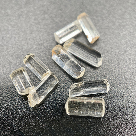 9-piece Burmese phenakite crystal lot on black background. Available at sanctuaryofstones.com