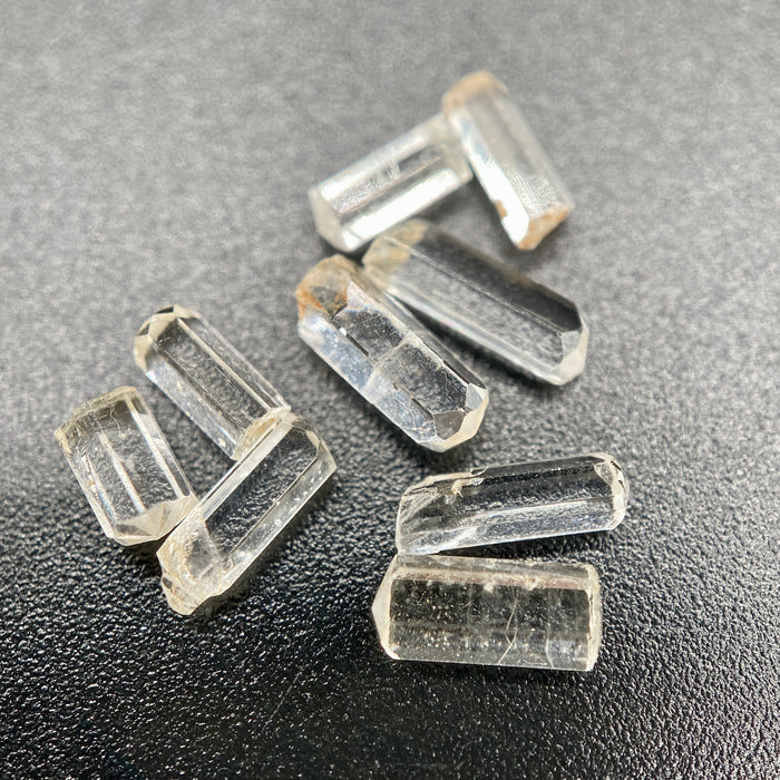 9-piece Burmese phenakite crystal lot on black background. Available at sanctuaryofstones.com