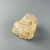 Etched rough Nigerian phenakite crystal with orange tint on grey background. available at sanctuaryofstones.com