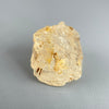 Etched rough Nigerian phenakite crystal with orange tint on grey background. available at sanctuaryofstones.com
