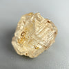 Etched rough Nigerian phenakite crystal with orange tint on grey background. available at sanctuaryofstones.com
